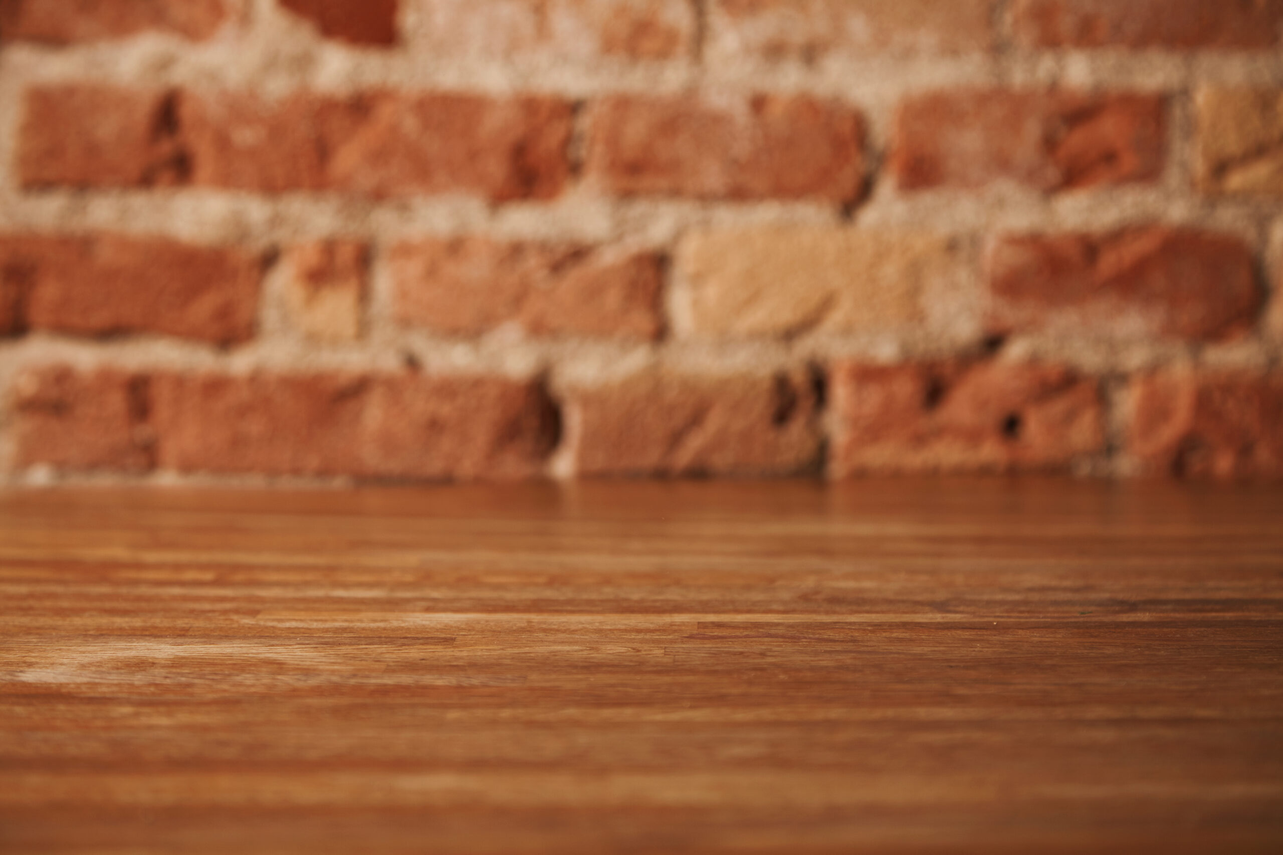 empty-rustic-brown-wooden-table-with-brick-wall-background-still-life-other-compositions-scaled.jpg